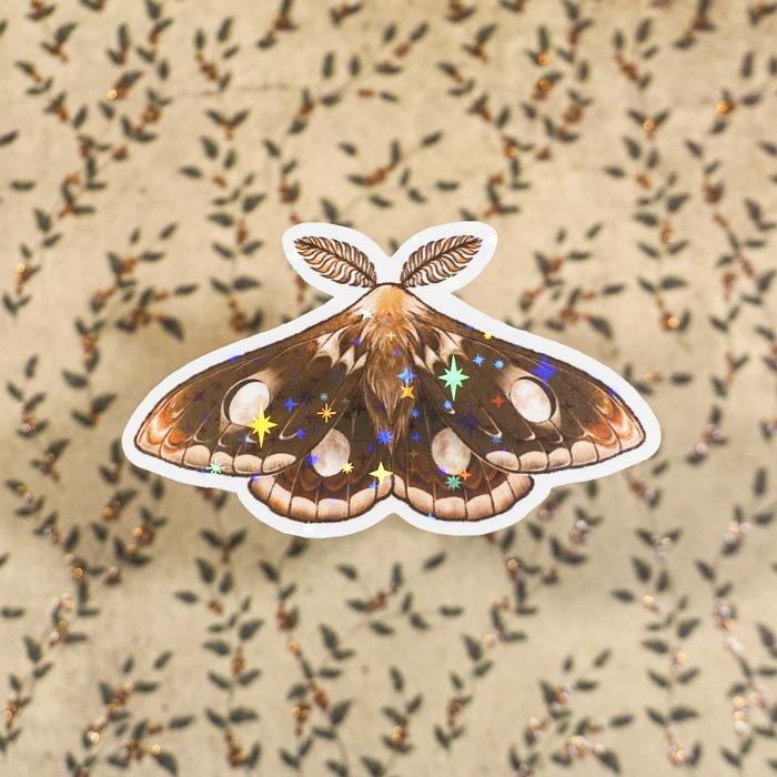 Holographic sticker of the Waxing Gibbous moth on a paper background from atelier persephone