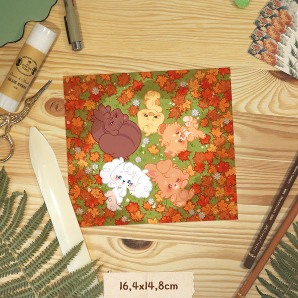 Square print representing ONEUS animals in the fall forest, on a wooden surface with craft supplies.