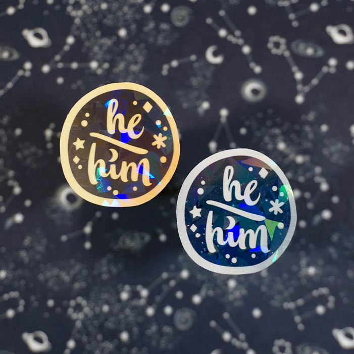 he him holographic sticker from the safe space lgbtq shop atelier persephone