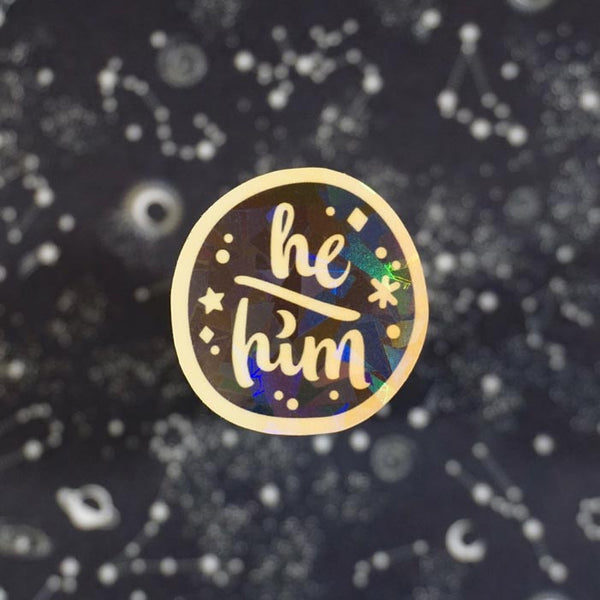 he him sticker on a dark background made by a lgbtq friendly business