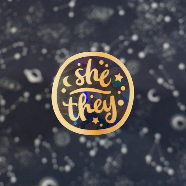 she they holographic stickers on a background with stars and galaxies from atelier persephone