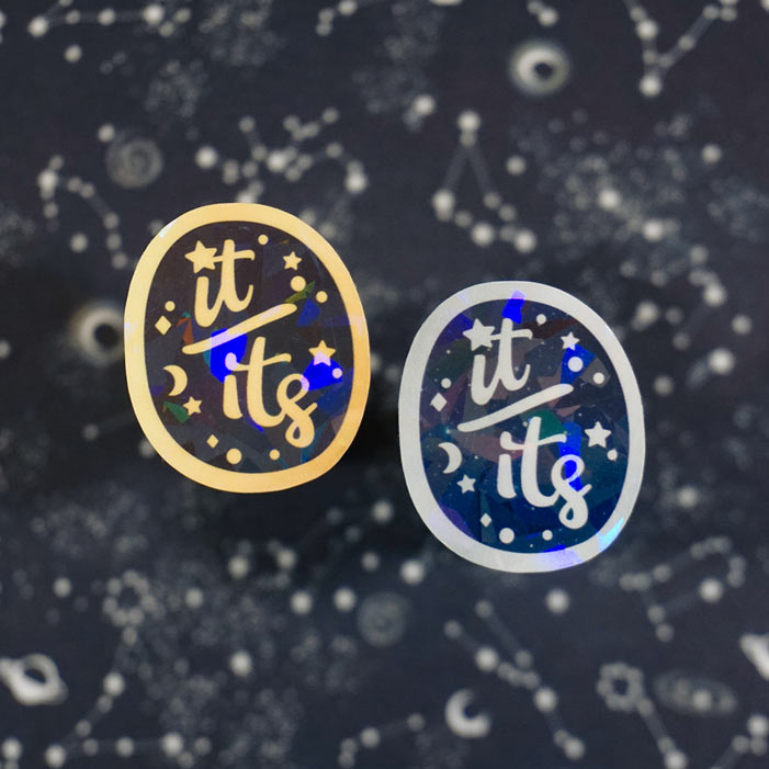 two it its stickers with holographic effect on a black background created by atelier persephone